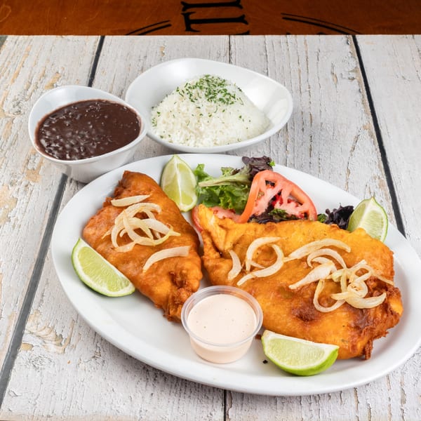Dennys Latin Cafe's fried fish with onions, lime, salad, rice, and black beans.